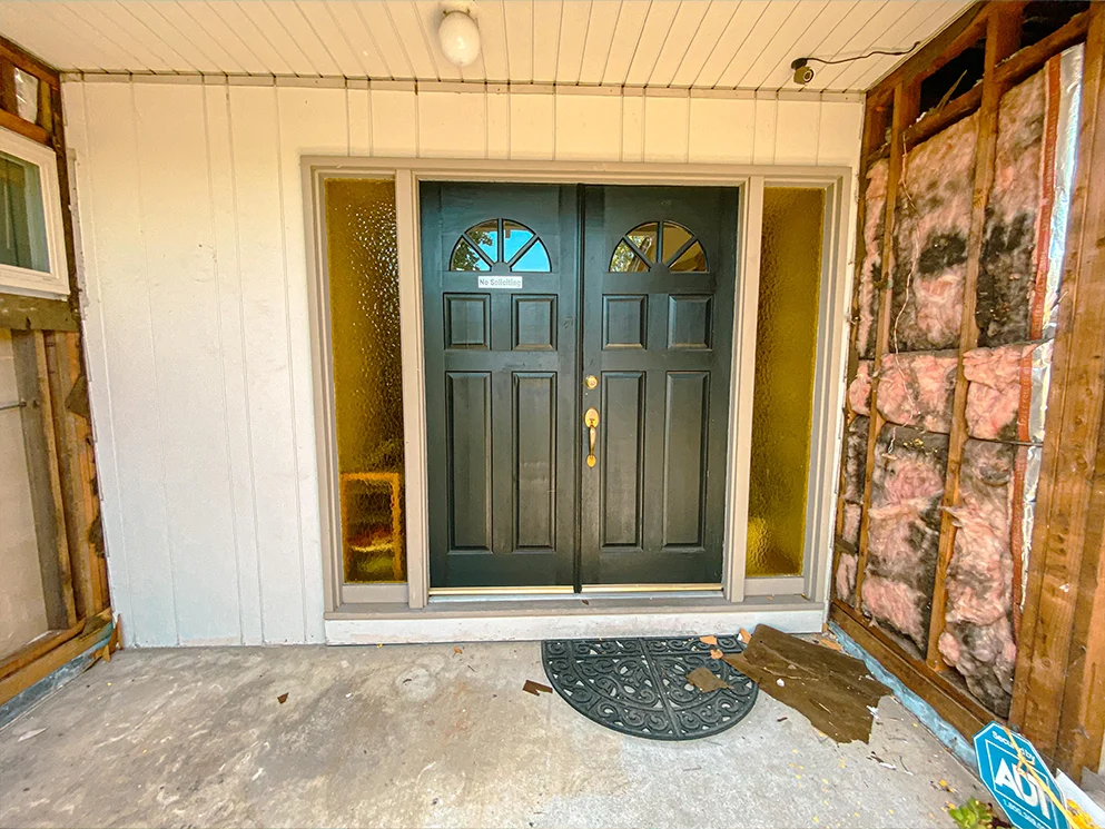 Front entry with siding opened to expose framing and insulation