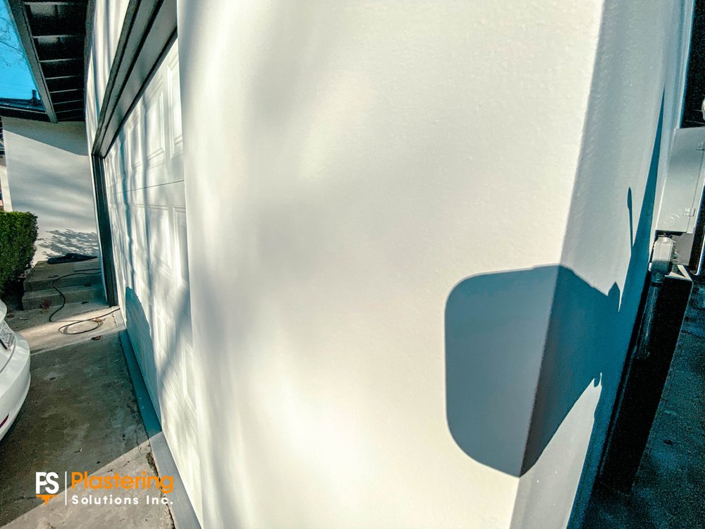 Close view of the finished smooth integrated color stucco at the garage