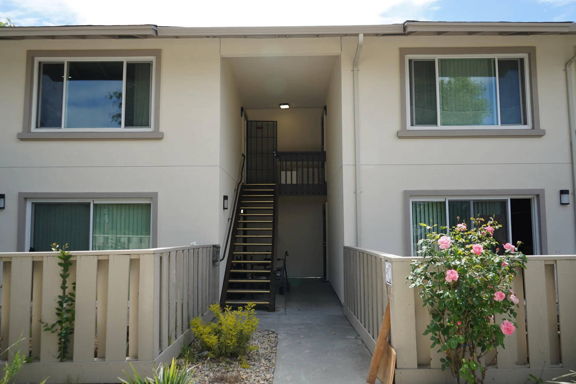Finished cream stucco at a Mayfair apartment stairwell entry with new trim