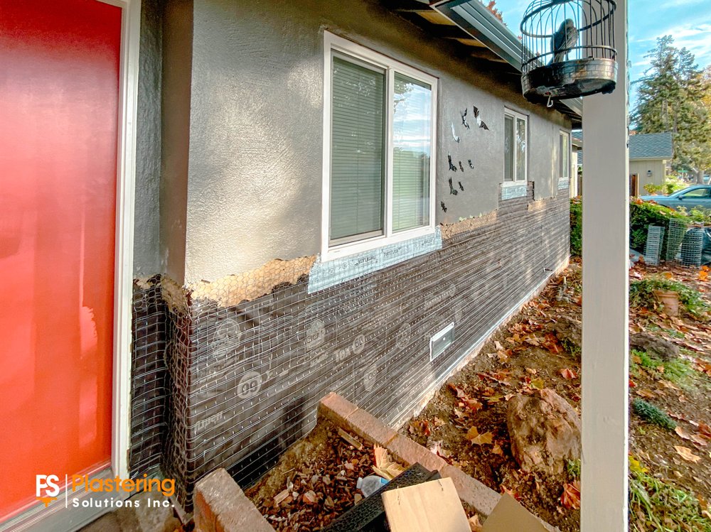 Weather barrier and wire lath installed on the lower wall beside the front door