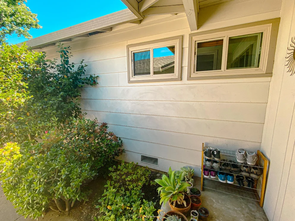 Lap siding and windows along the entry walkway before conversion