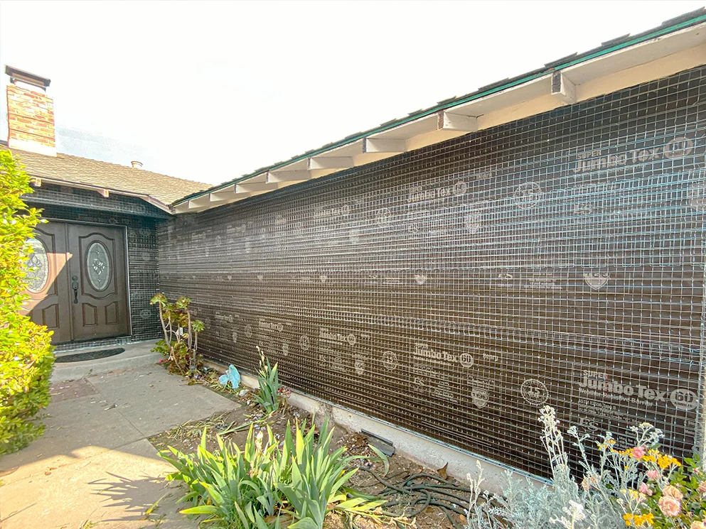 Exterior wall rebuilt with building paper and metal lath during a full re-stucco project