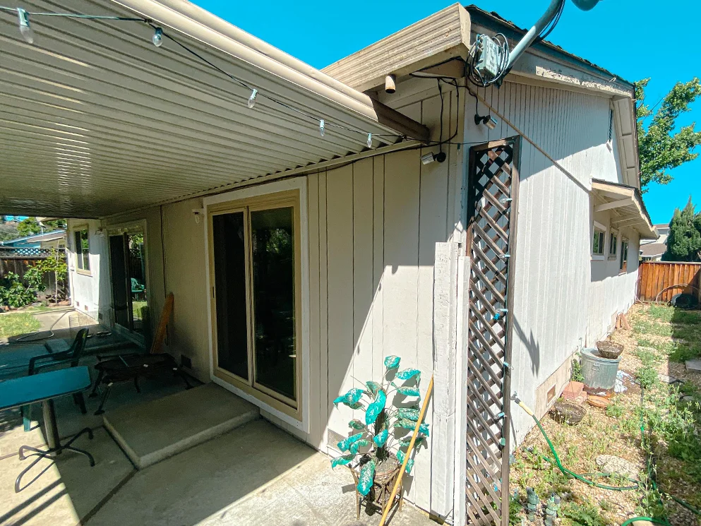 Rear patio wall with vertical siding before the stucco conversion