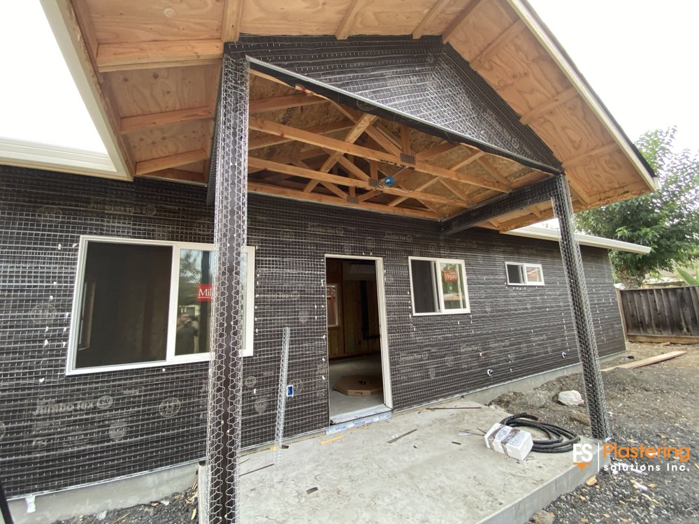 Covered porch with weather barrier and lath on the walls and columns