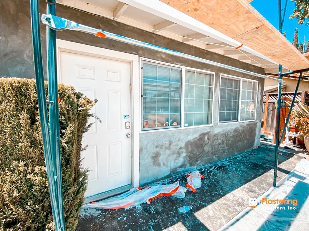 Front entry wall with the base coat applied around the door and windows