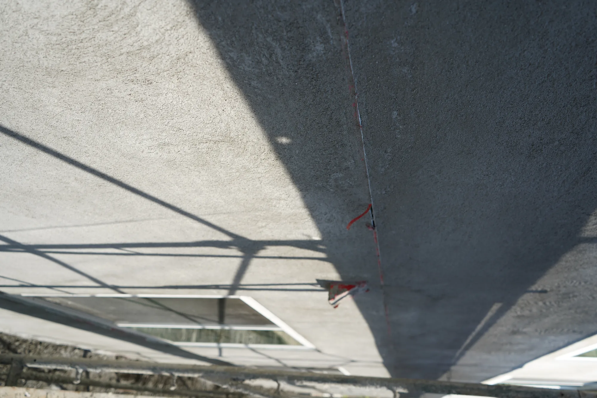 Close view of the brown coat texture and control joint on an apartment wall