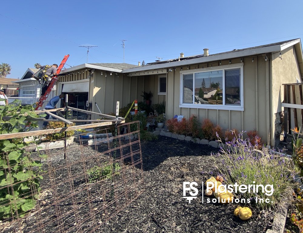 Single story home with dated board and batten siding before the exterior was rebuilt