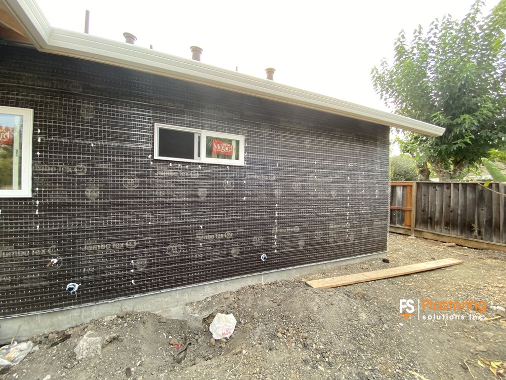 Rear wall fully wrapped in weather barrier and wire lath
