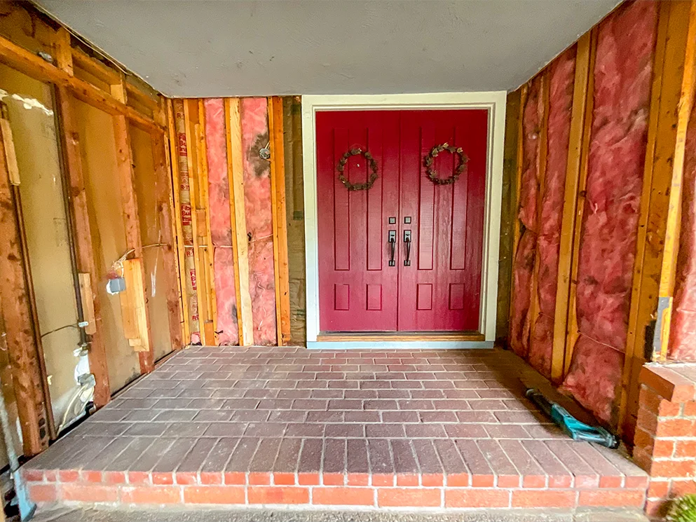 Front entry with the walls opened to the studs and insulation