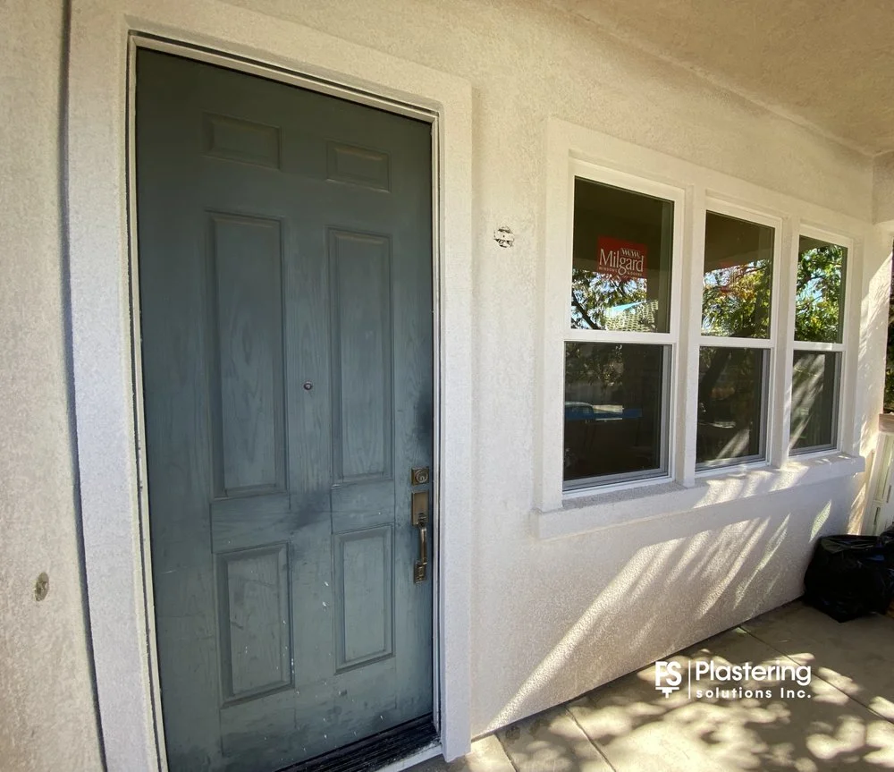 Finished stucco around a front door and new porch windows