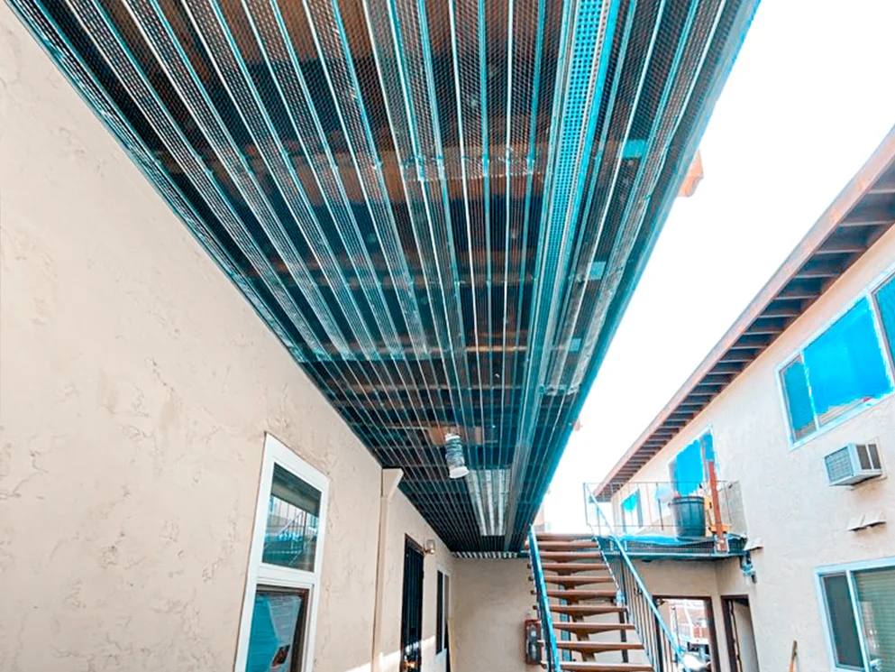 Metal lath installed across the underside of an apartment walkway