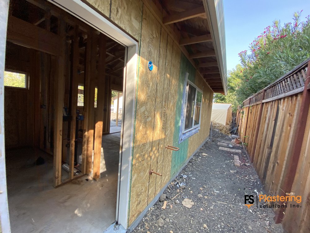 Interior framing seen through the doorway with weather barrier on the side wall