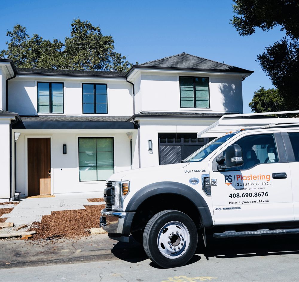 Crew applying a fresh stucco coat on a house wall