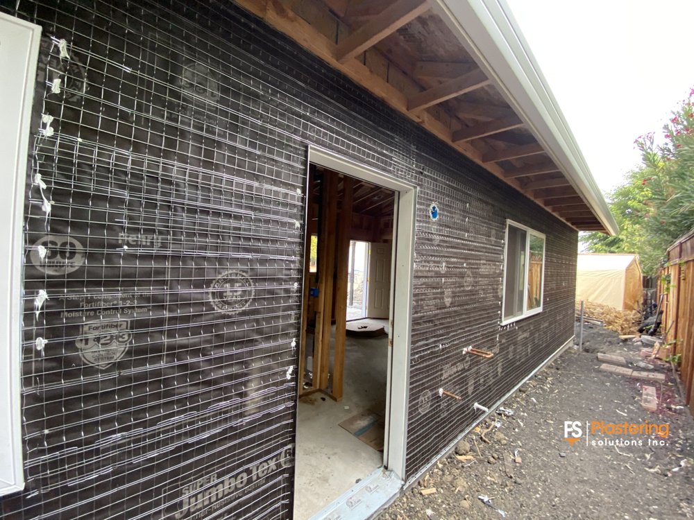 Close view of weather barrier and wire lath beside an open doorway
