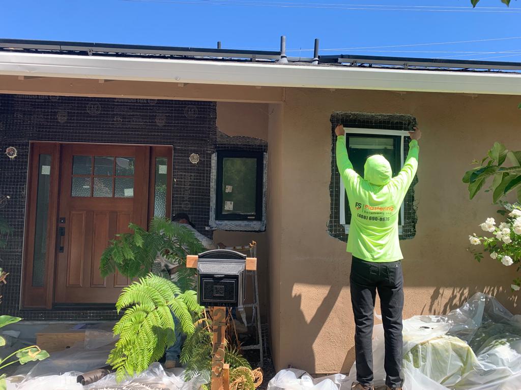 Plastering Solutions crew member working around newly installed windows in San Jose
