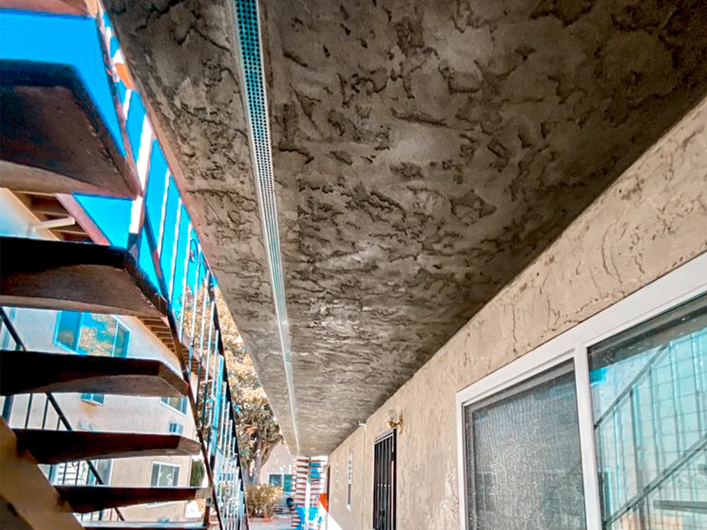 Fresh stucco coat on the underside of an apartment walkway