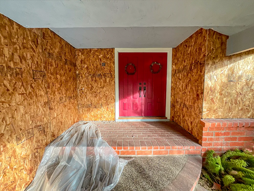Covered entry with new structural sheathing around the red doors