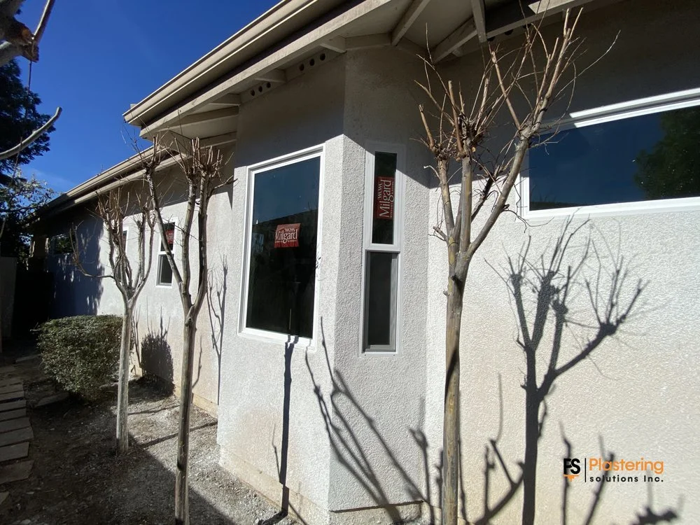 Completed bay wall with new windows set in finished stucco