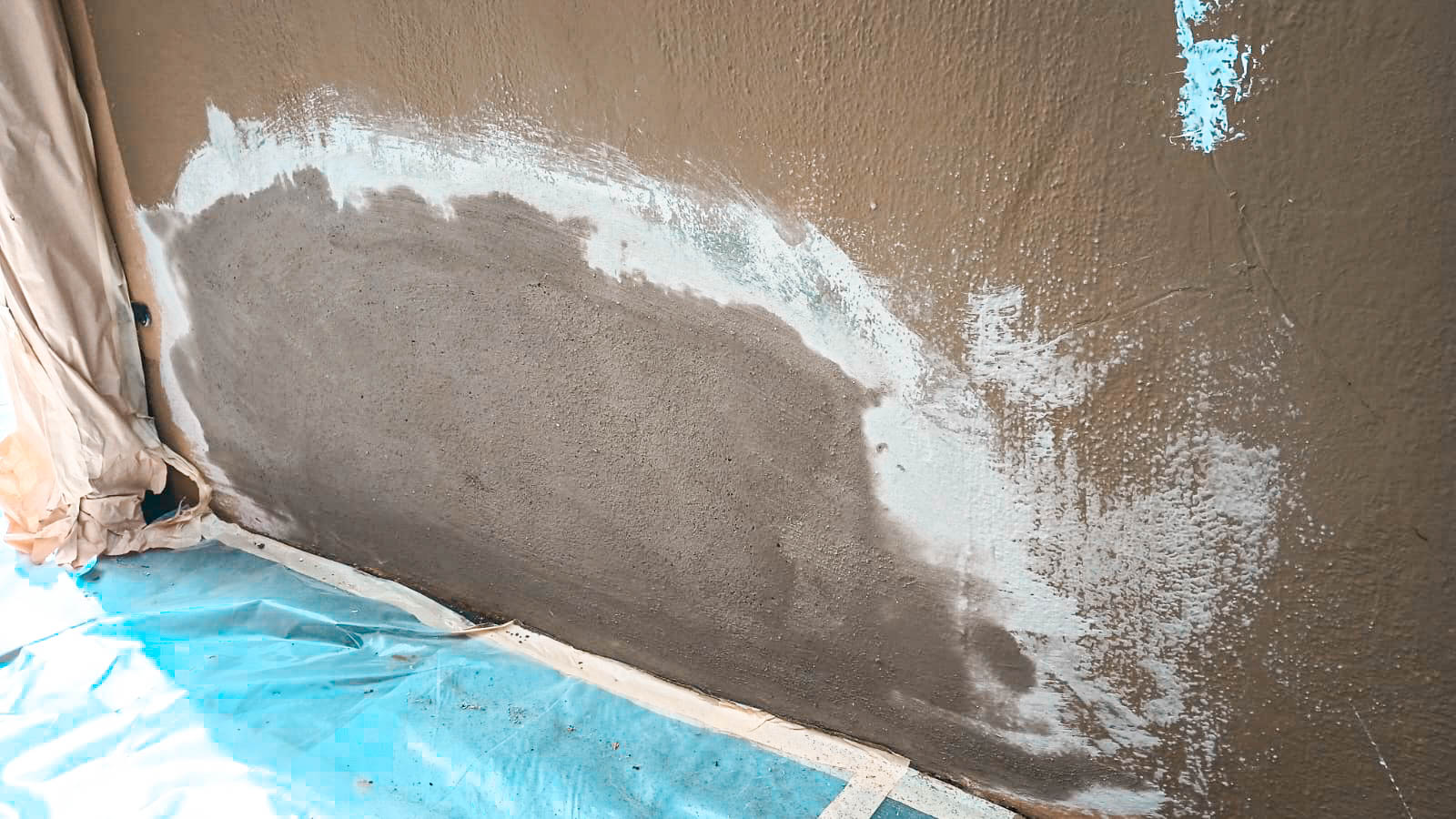 Exterior stucco wall patch being blended into the surrounding finish