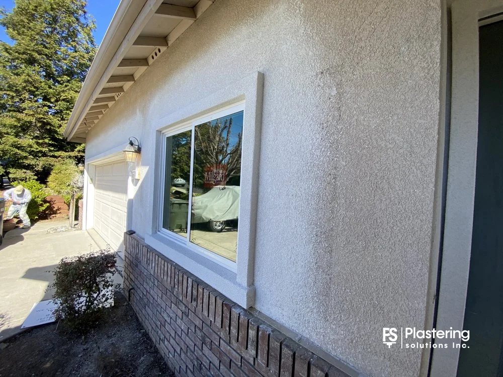 Completed replacement window set into a freshly finished stucco wall