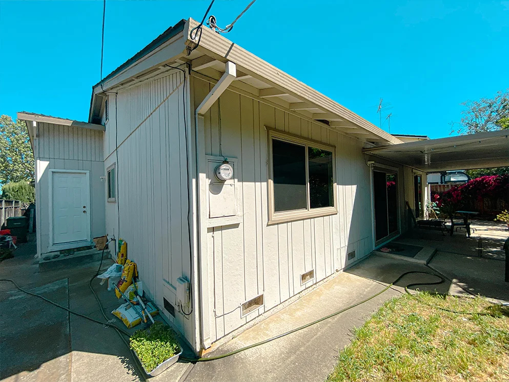 Back corner of the home with vertical siding before conversion