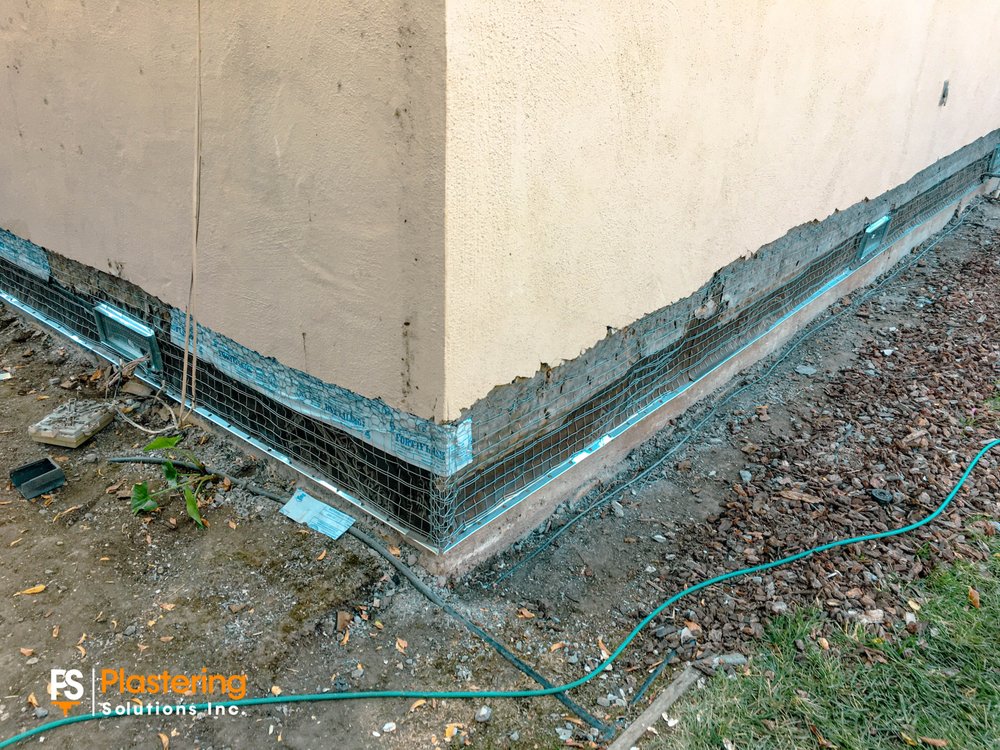 Metal lath installed along the base of a stucco wall at the home corner