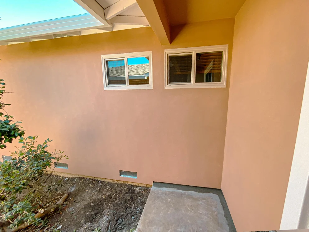 Entry side wall with the finished acrylic smooth stucco around the windows