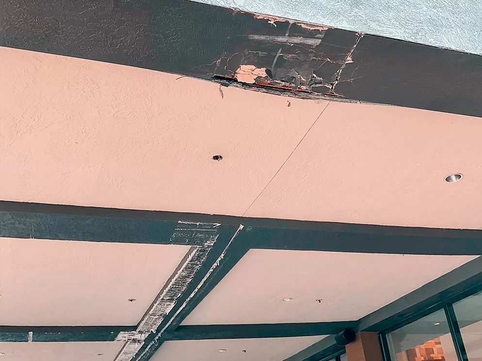 Damaged weather barrier on the canopy underside before repair