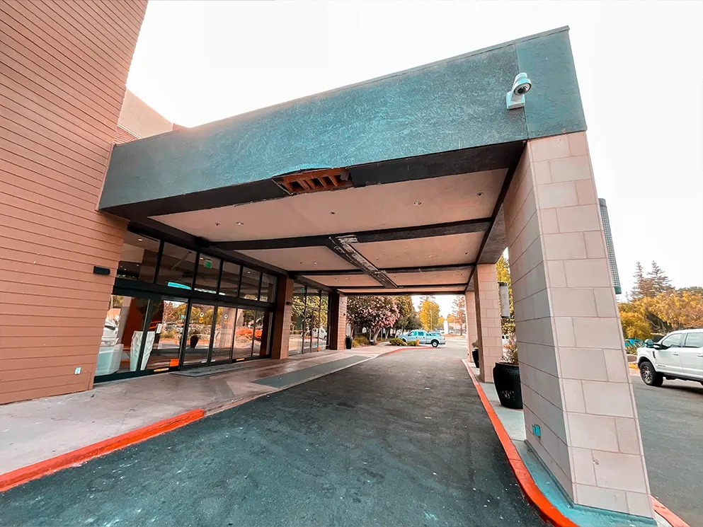 Repaired canopy beam with fresh finish above the commercial entrance