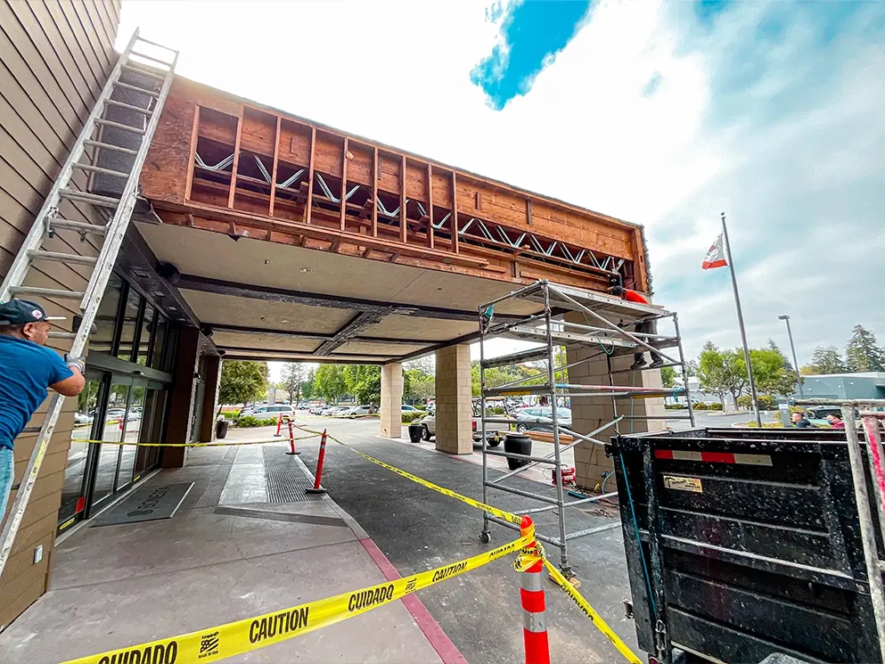 Crew rebuilding the canopy framing with flashing and lath from scaffolding