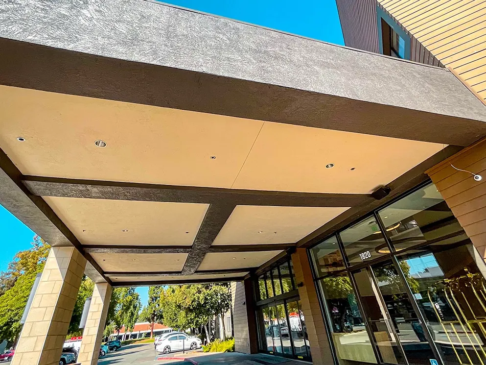 Finished textured stucco fascia on the repaired canopy beam