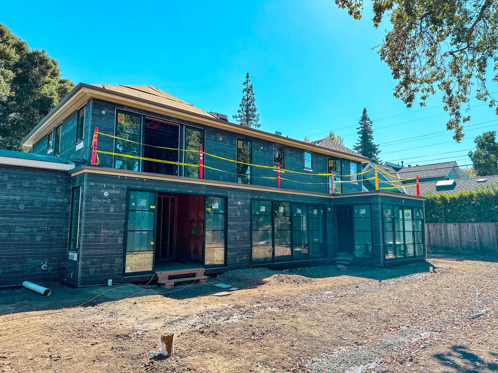 Two story exterior renovation with new doors and windows ready for stucco