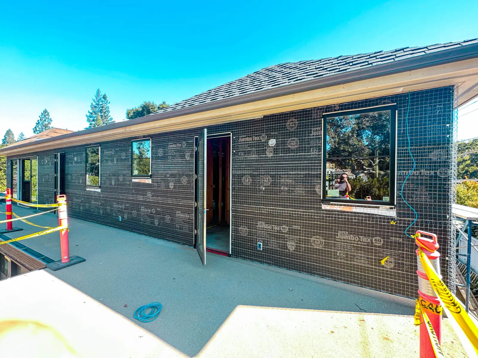 Entry door and replacement windows installed in an exterior wall prepared for stucco