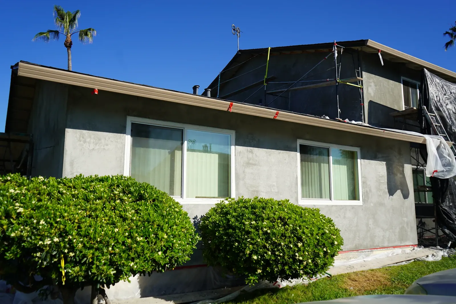 Apartment side elevation with brown coat around new windows and landscaping