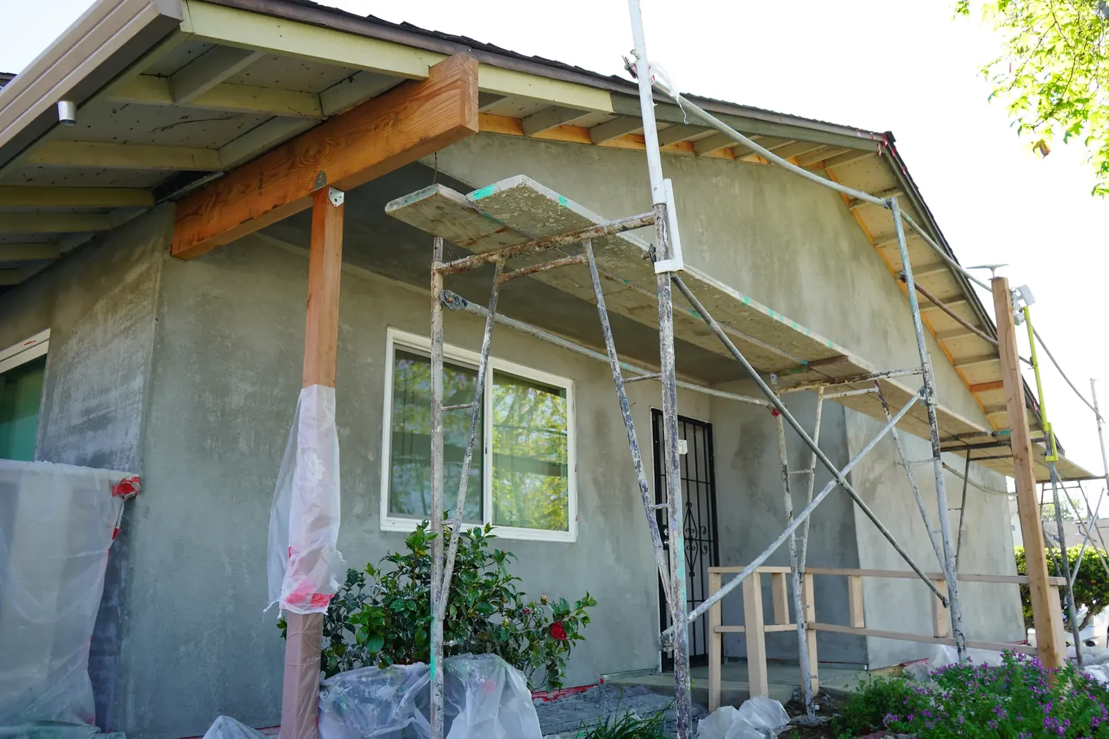 Apartment entry with a new wood porch beam and brown coat on the walls