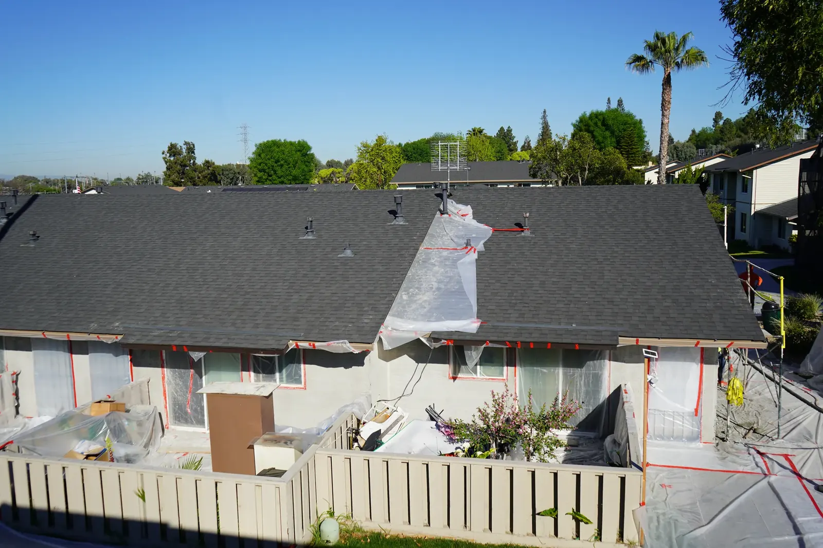 Rear apartment patios and windows protected with plastic during stucco work