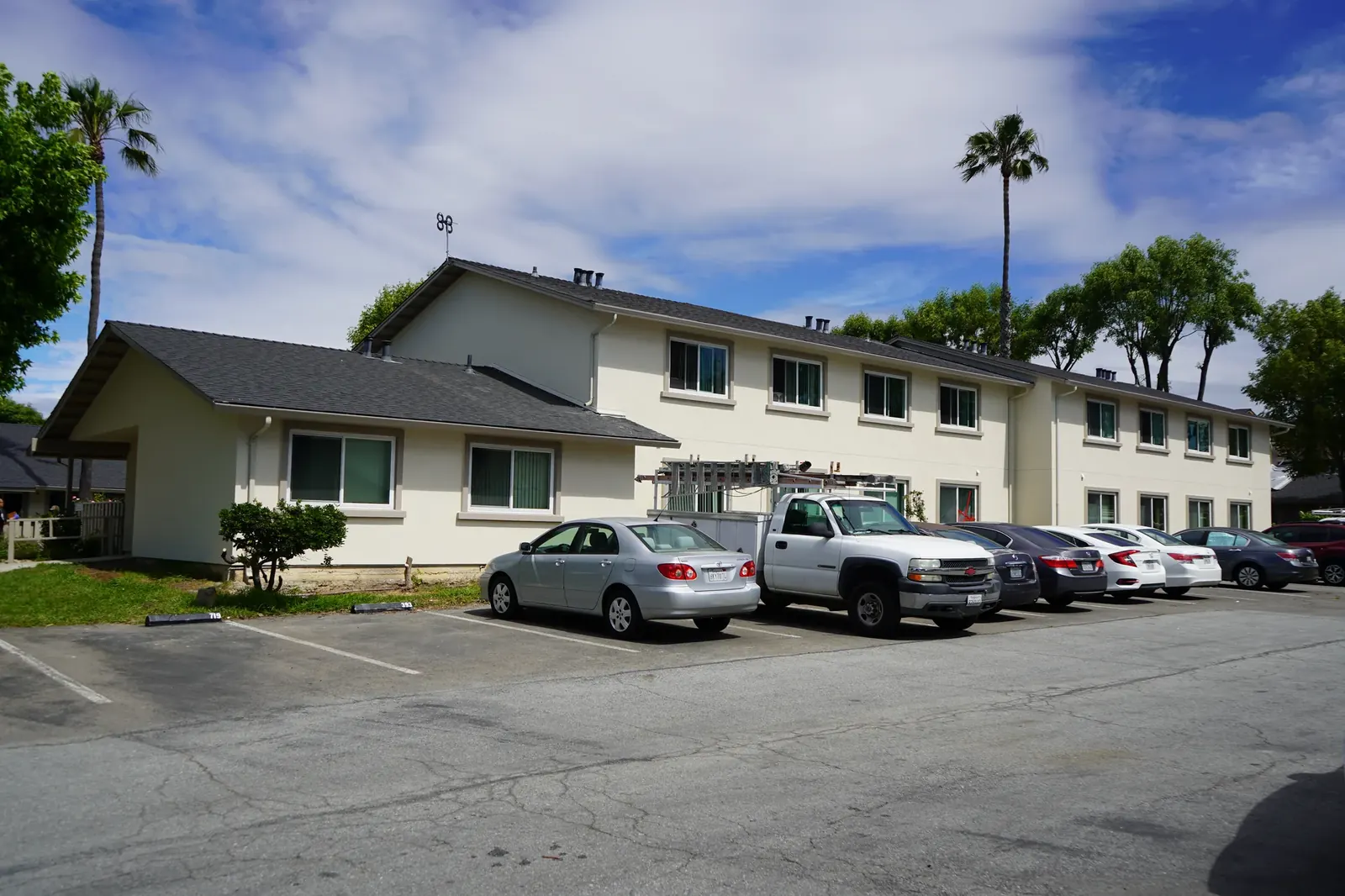 Finished Mayfair apartment buildings with cream stucco viewed from the parking lot