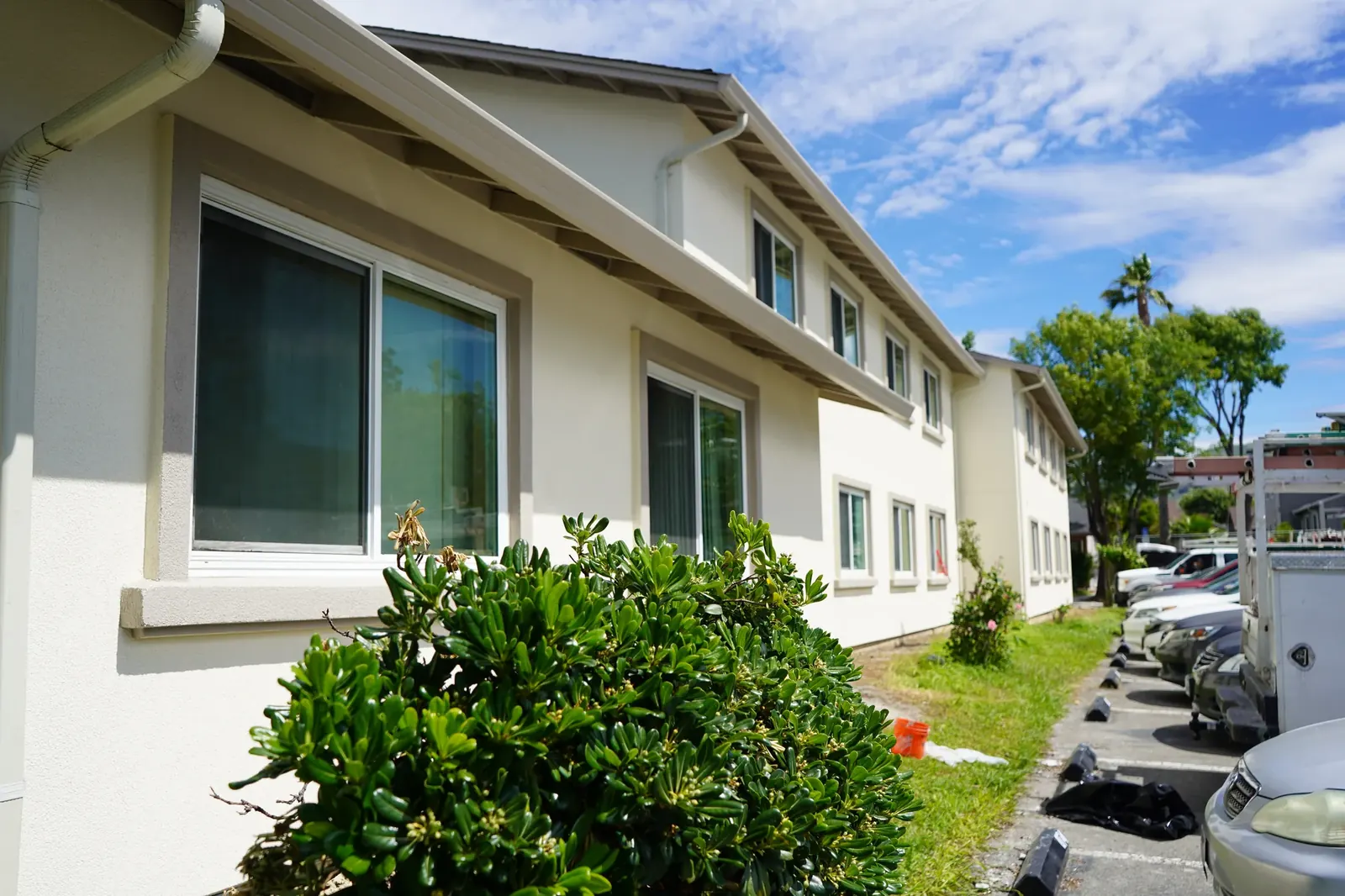 Close view of finished cream stucco and window trim along an apartment building