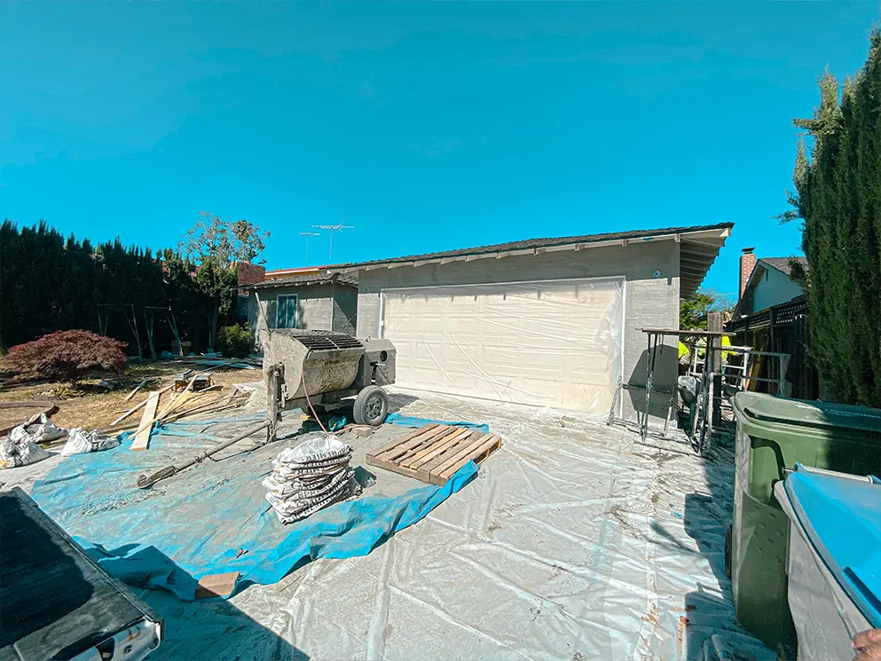 Garage with the scratch coat applied and the driveway protected