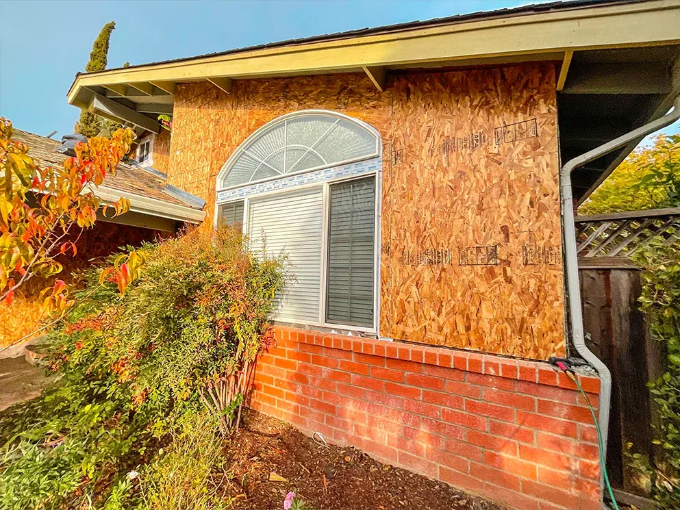New sheathing installed around the arched window above the brick base
