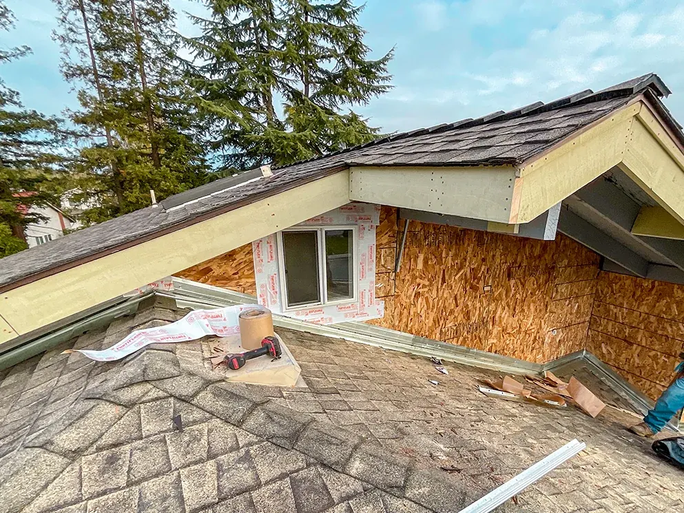 Weather resistive barrier around an upper window with sheathing along the roofline