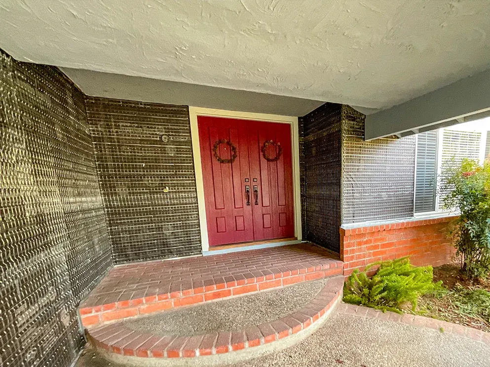 Covered entry wrapped in building paper and metal lath around the red doors