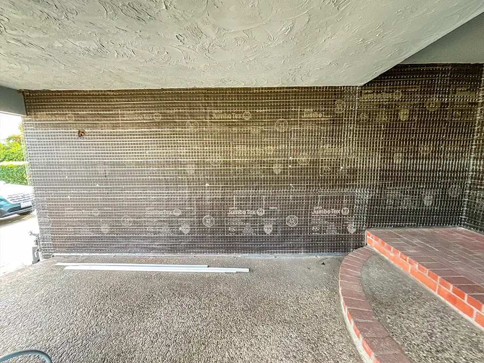Porch wall covered in building paper and metal lath