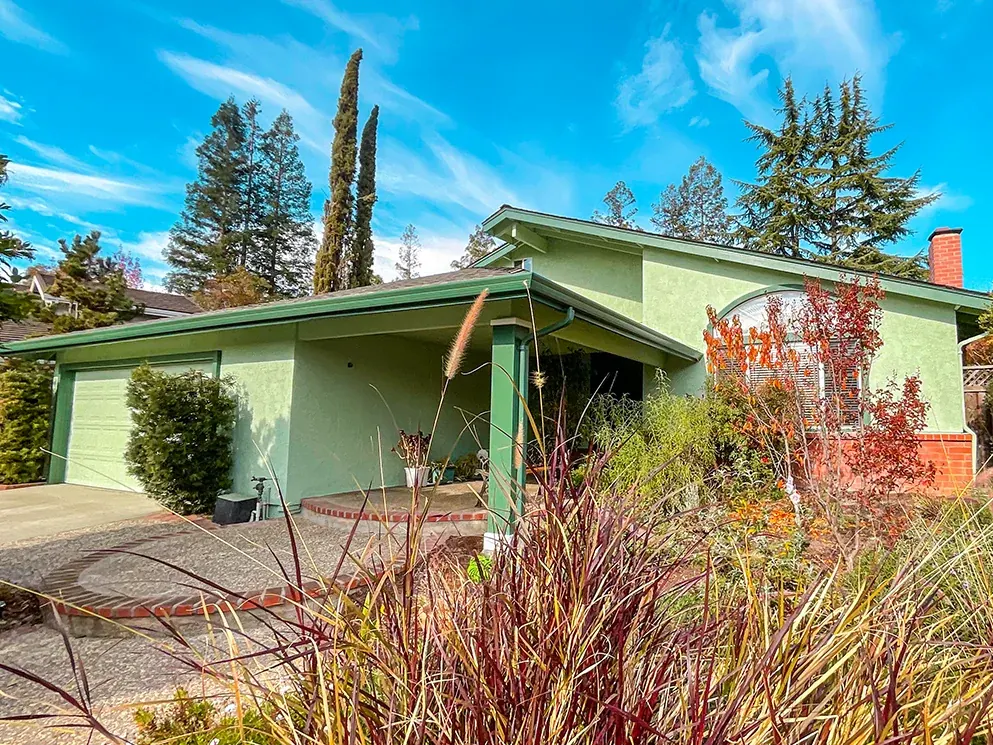 Front of the home with the completed green stucco exterior