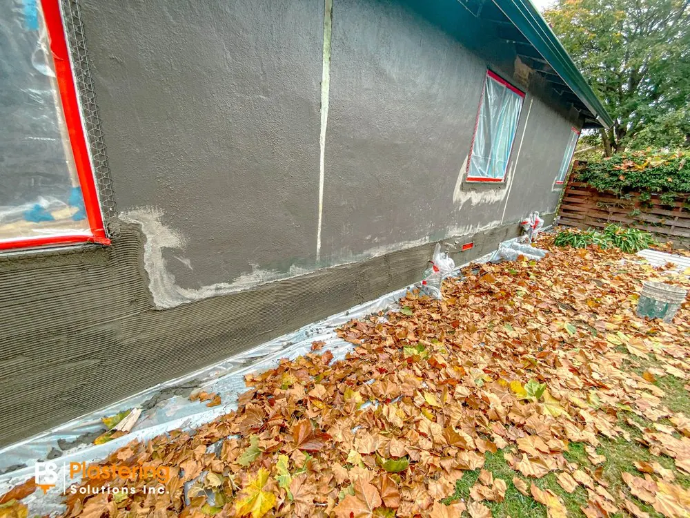 Scratch coat applied along the lower wall where the new base meets the existing stucco