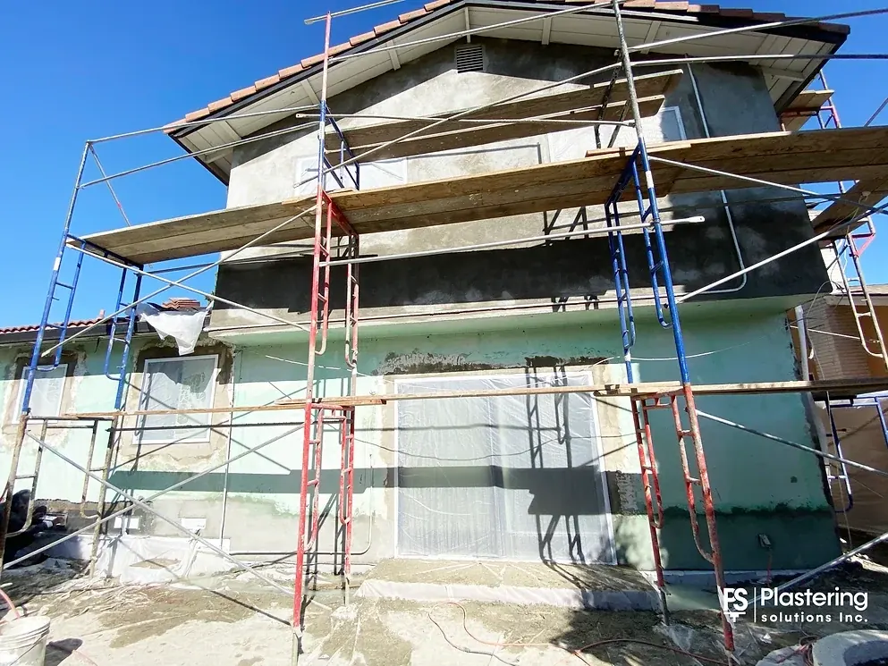 Scratch coat applied on the upper walls with windows and doors masked