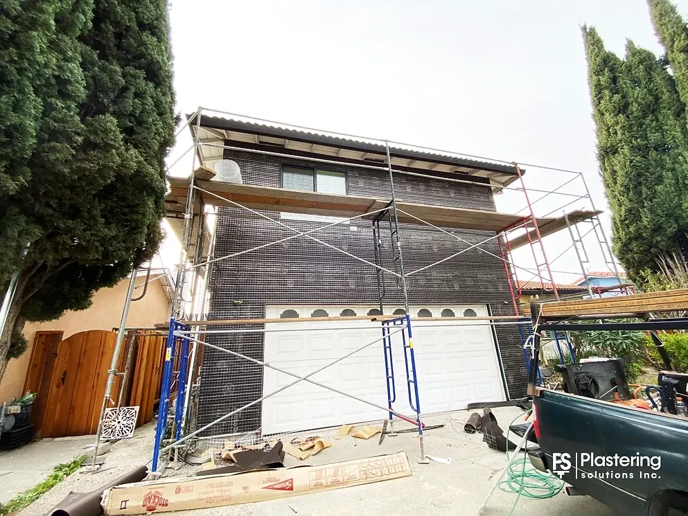 Building paper and metal lath installed across the front of the home